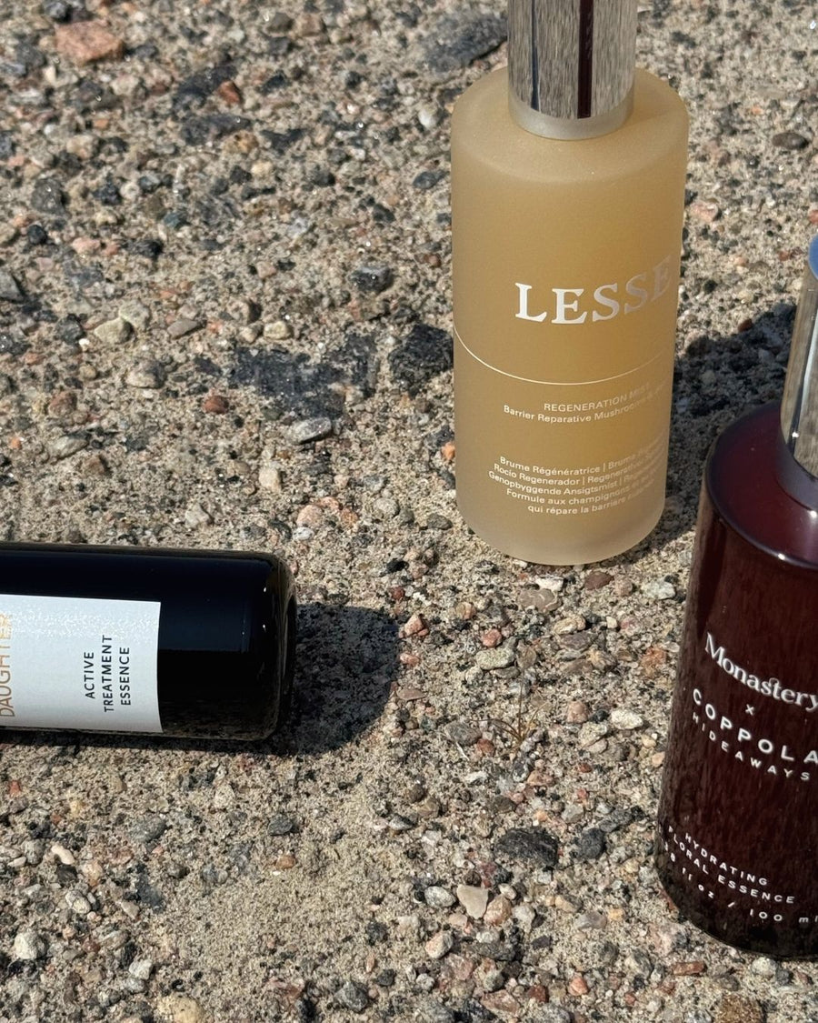 Bottles of essences and mists for sunburned skin against a neutral background 
