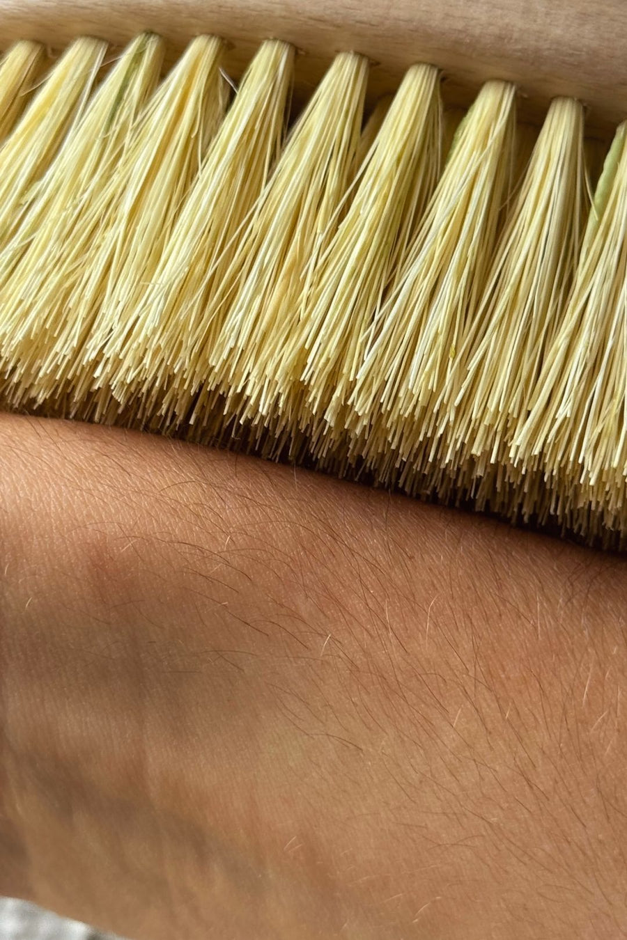 Close-up of a vegan dry brush  against the skin for lymphatic drainage