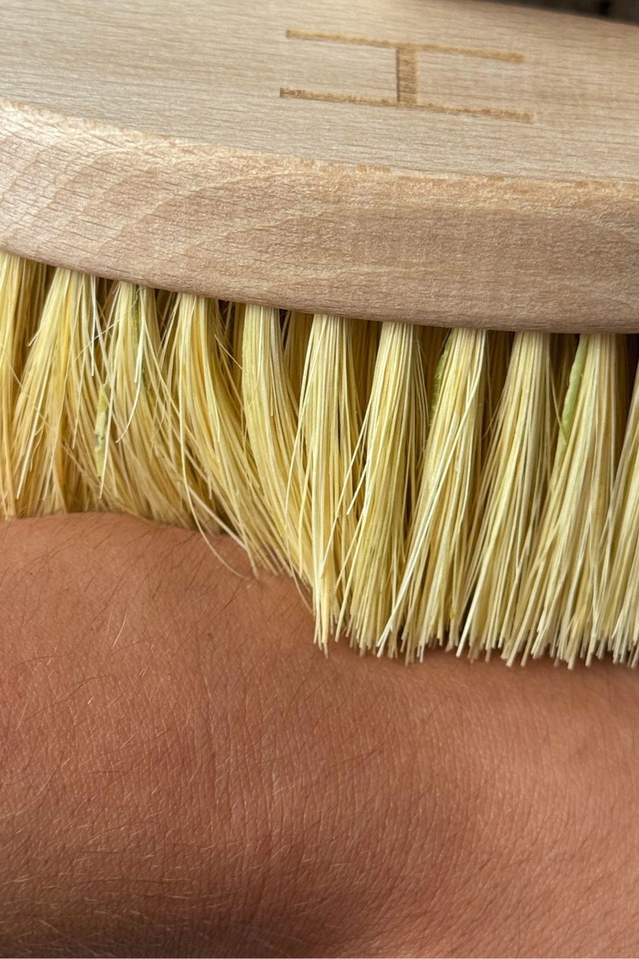 Close-up of a dry brush being used on a person's armpit to drain lymph 